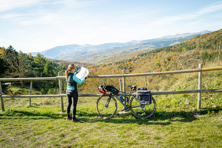 Ciclista consultant un mapa de les Ecovies de Girona al mirador de Coll d'Ares