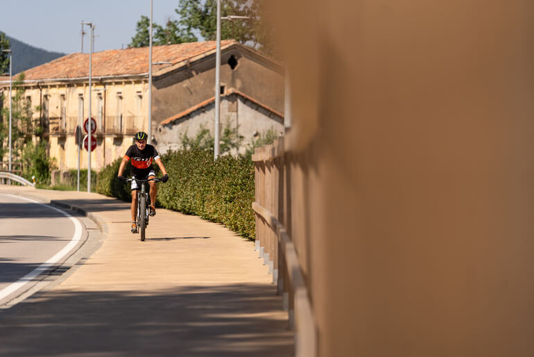 Ciclista pedalant a la Colònia Llaudet, via temàtica de l'Alt Ter