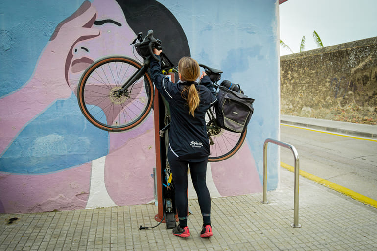 Ciclista reparant la seva bicicleta a un punt de càrrega i autoreparació