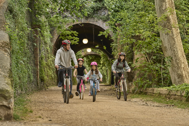Família pedalant a la via verda del Carrilet a Olot