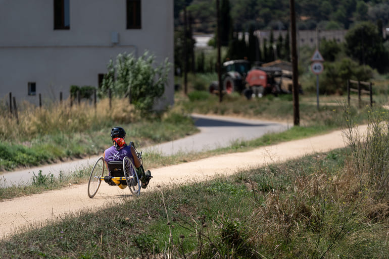 Jove amb una handbike a la via verda del Tren Petit